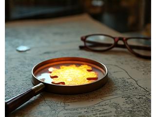 Lupa sobre un mapa antiguo con pistas y notas, representando un misterio o una investigación detectivesca.